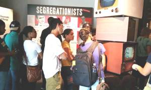 Group of students look at a museum exhibit together.