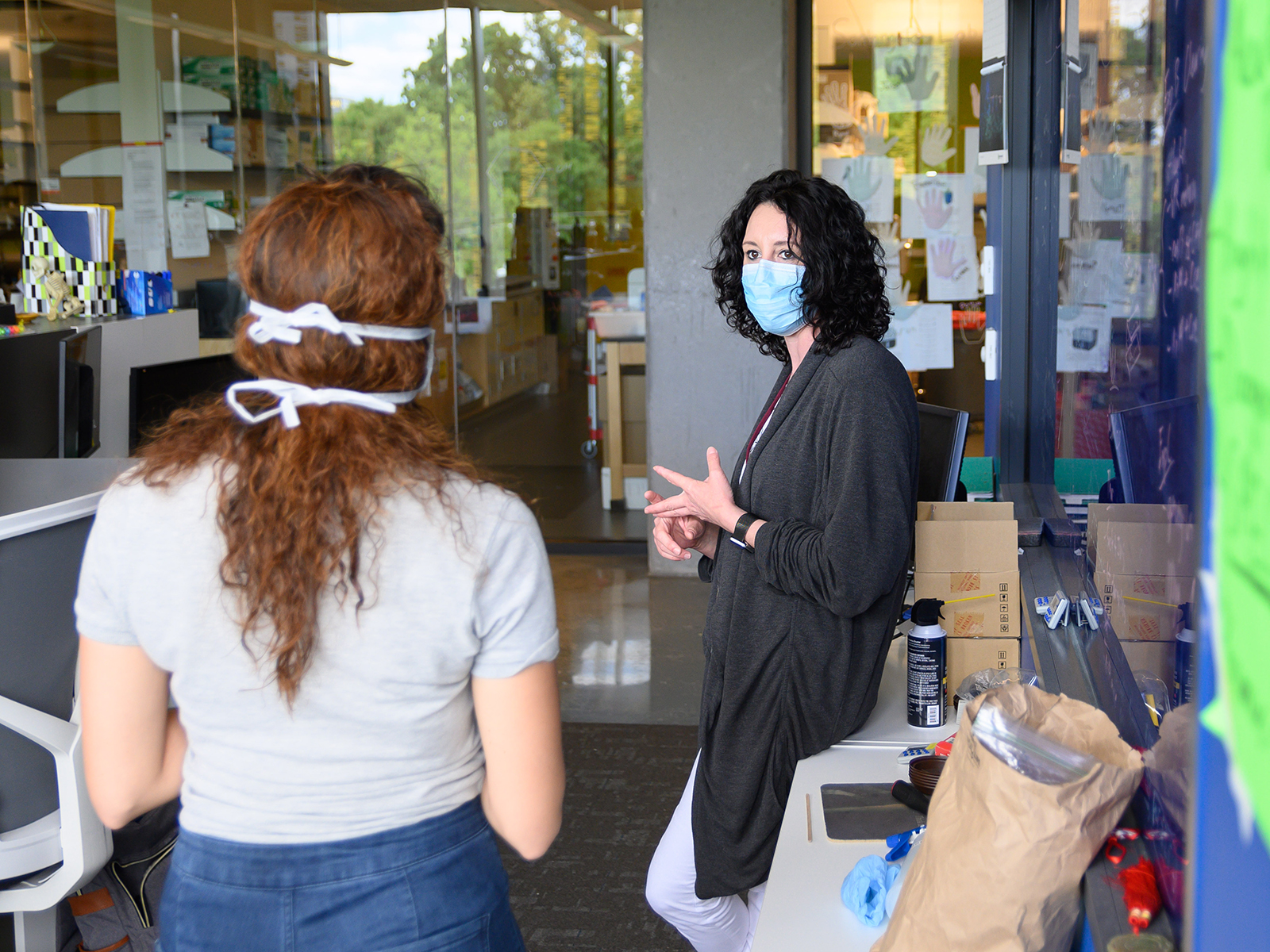 Researchers wear masks and practice distancing in the workspace in the Krone Engineered Biosystems Building