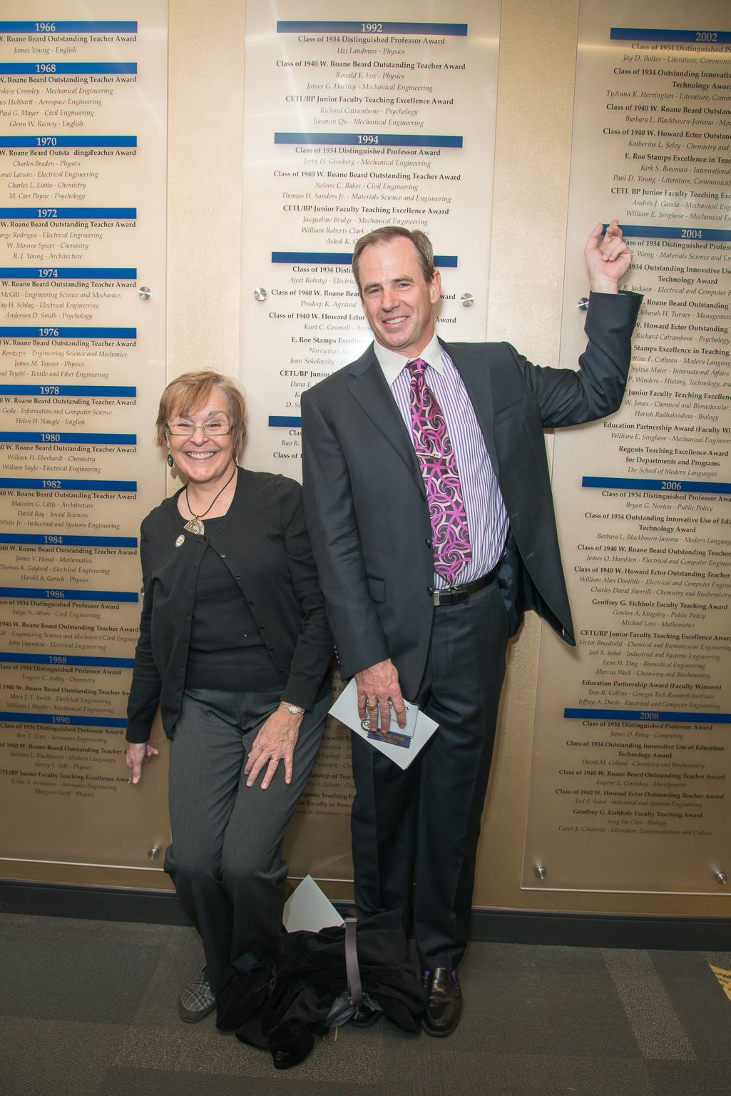 Margaret Graff and Bill Singhose point to their names on the Teaching Excellence Wall. 